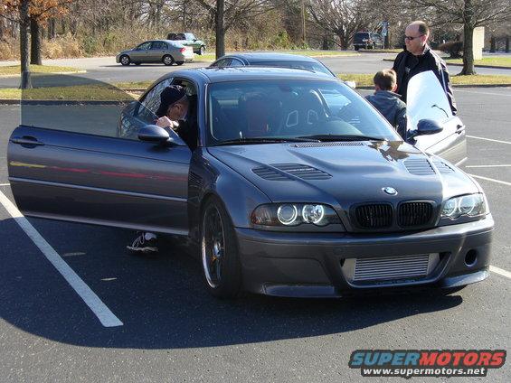 Dark gray BMW M3 E46 coupe with driver's door open, front intercooler visible