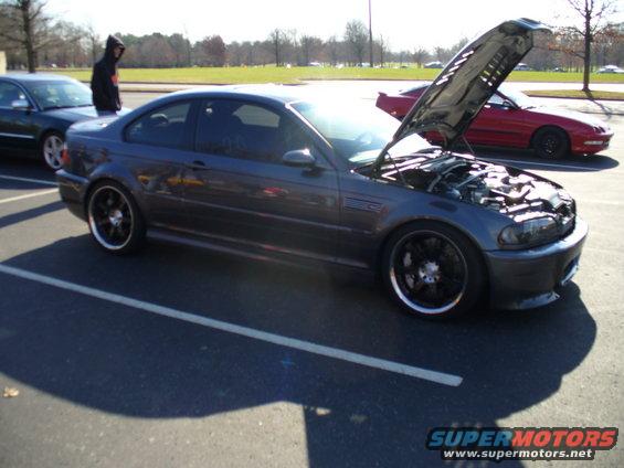 Dark gray coupe with hood open, showing engine bay