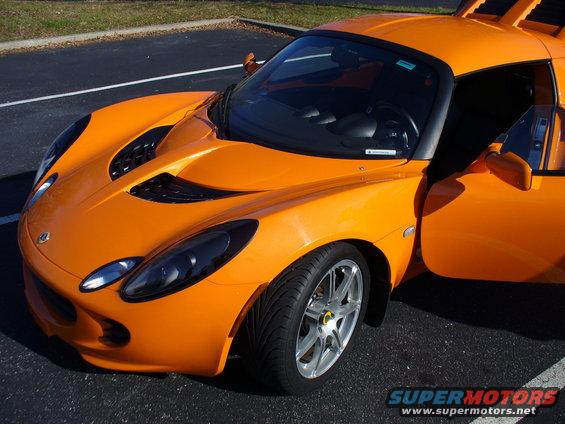 Orange Lotus Elise sports car with driver's door open