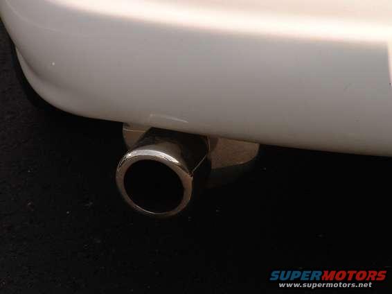 Close-up of a chrome exhaust tip on a white car