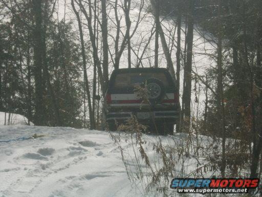 Rear view of a 1990 Ford Bronco in the snow with a spare tire on the back