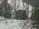 1990 Ford Bronco - A 1990 Ford Bronco is seen from the rear, parked in a snowy, wooded area with its spare tire mounted externally.