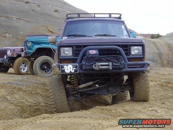 Dark brown Ford Bronco II with a winch and brush guard, front view, off-road