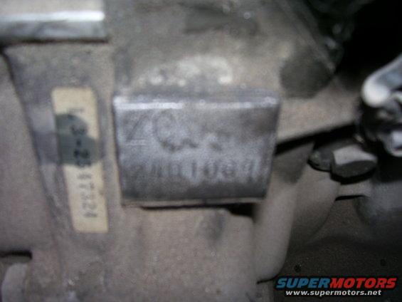 Close-up of a metal plate with stamped numbers and a label with text
