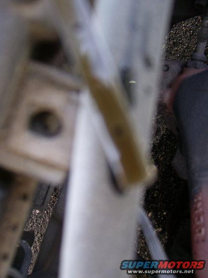 Close-up of a yellow fluid level indicator in an engine bay