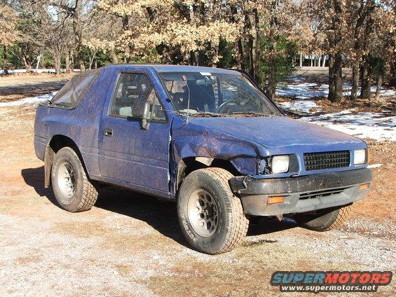 Blue SUV with a soft top, damaged front fender and bumper. Appears to be an Isuzu Rodeo