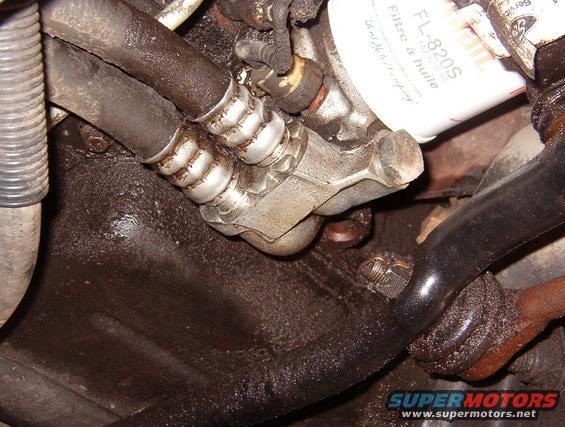 oillines1.jpg The clip is permanently attached to the line on the R.  After removing the bolt from the top (not visible), swing the clip up to separate the lines.