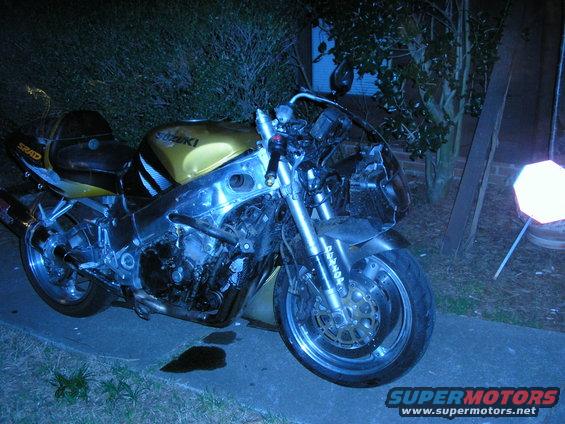 Gold Suzuki motorcycle with SRAD on the seat, parked outside
