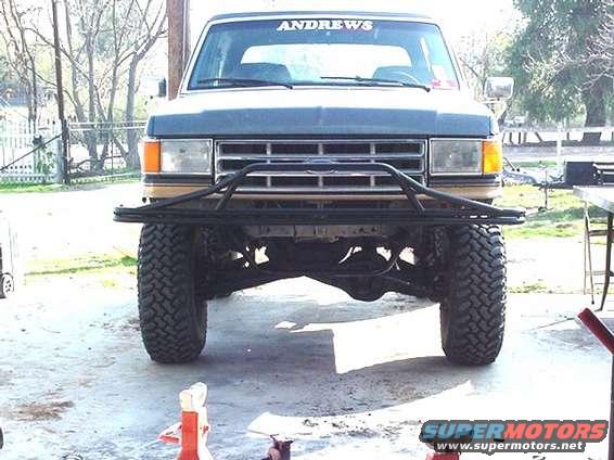 Front view of a Ford F-Series truck with a custom bumper and large tires. 'ANDREWS' is visible on the windshield banner