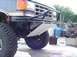 1988 Ford Bronco - Close-up of a truck's front end, focusing on the bumper and off-road tire.