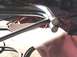 1988 Ford Bronco - Close-up of a chrome bumper guard with visible welding and red cables coiled nearby.
