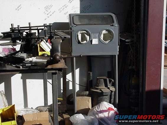 Gray sandblaster cabinet with two glove ports and a window