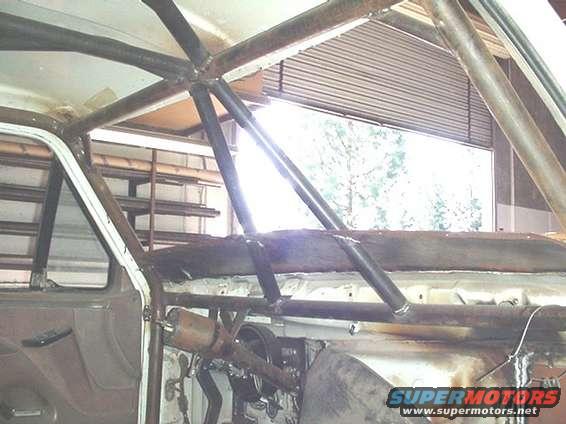 Interior view of a vehicle with a custom roll cage installed. Supermotors.net watermark visible