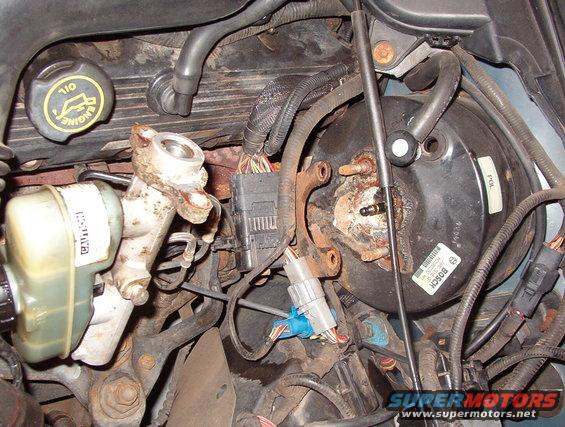 02booster.jpg Move the wiring harness connector bracket off the studs, then pull the master cylinder forward to allow clearance for the booster.  The brake lines do not need to be disconnected, even if they're hard steel.  They can be bent safely.