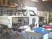 1988 Ford Bronco - A white Ford Bronco body is undergoing extensive modifications in a workshop setting.