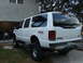 2000 Ford Excursion - Rear view of a lifted white Ford Excursion with FX4 Off-Road badging.