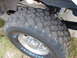 2000 Ford Excursion - A close-up view of a large off-road tire and suspension components, with 'BUCKSHOT' visible on the sidewall.