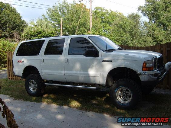White 2000 Ford Excursion SUV, lifted with aftermarket wheels and side steps