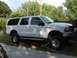 2000 Ford Excursion - White 2000 Ford Excursion SUV parked outdoors with a lifted suspension and custom wheels.