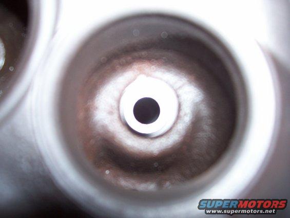 Close-up view into a cylinder head valve seat with a central hole