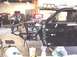 1988 Ford Bronco - A black truck chassis, likely undergoing modification or repair, is shown with its engine exposed and a portion of the body attached.