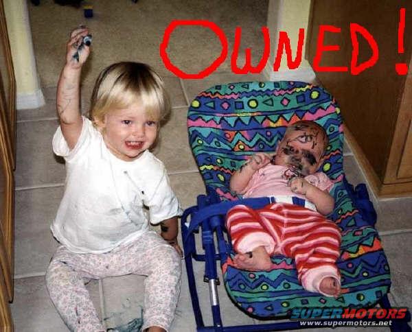 kid with arm up, covered in dirt, next to baby in chair, also covered in dirt. Red text says OWNED!
