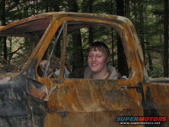 Burnt out truck cab interior with a smiling person