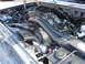 1989 Ford Bronco - Close-up view of a vehicle's engine bay, showing various hoses, the intake manifold, and other engine components.
