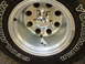 1989 Ford Bronco - Toy truck and trailer placed inside the rim of a vehicle wheel.