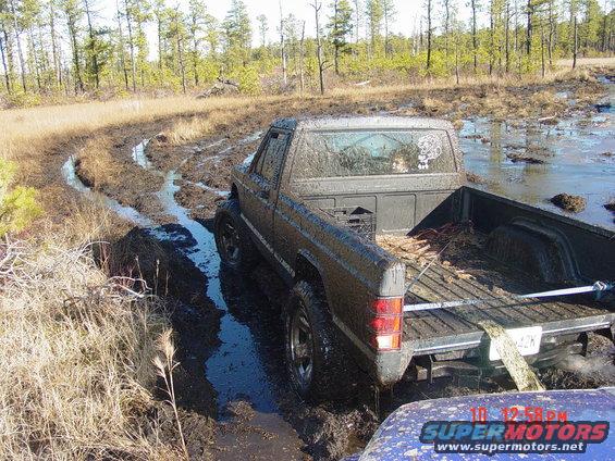 Dark pickup truck stuck in mud, rear view. 1995 Dodge 1500
