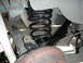 1990 Ford Mustang - Close-up of a vehicle's rear suspension components, including a coil spring and shock absorber.