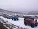 2003 Ford Ranger - Several modified trucks and SUVs drive in a convoy through a snow-covered landscape.
