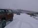 2003 Ford Ranger - Multiple vehicles navigate a snowy path during a winter outing, with a brown truck in the foreground and a white SUV further down the road.