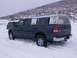 2003 Ford Ranger - Two trucks driving in the snow on a hillside, one with a white camper shell.