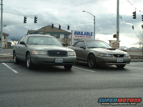 Tan Ford Mustang convertible with a hood scoop parked in a lot