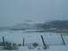 2003 Ford Ranger - A winter scene with snow-covered fields and a distant hill under a cloudy sky.