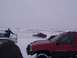 2003 Ford Ranger - Several off-road vehicles are seen in a snowy landscape with a person standing by one of them.