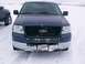 2003 Ford Ranger - A dark blue Ford F-150 truck is parked in the snow, showing its front grille and bumper.