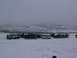 2003 Ford Ranger - A group of vehicles are parked in a snow-covered landscape with hills in the background.