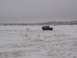 2003 Ford Ranger - A red SUV is being towed across a snowy landscape with distant hills under a cloudy sky.