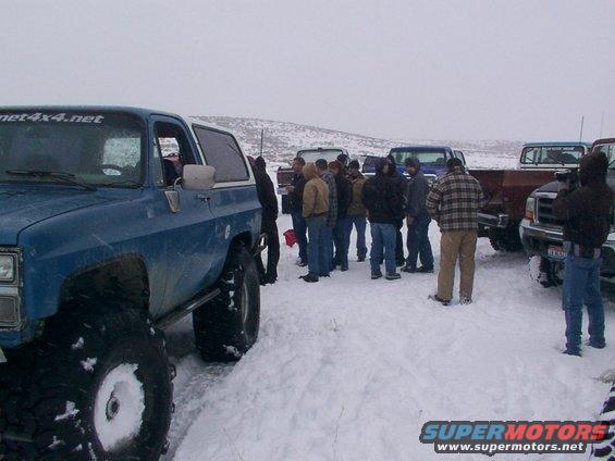 Blue SUV with oversized tires and a white roof, parked in snow. Text 'net4x4.net' visible on windshield