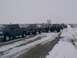 2003 Ford Ranger - A convoy of trucks drives down a snow-covered road under a cloudy sky.