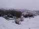 2003 Ford Ranger - Two SUVs navigate a snow-covered rural landscape with hills in the background.