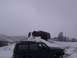 2003 Ford Ranger - Two SUVs navigate a snowy terrain, one climbing a rock formation.