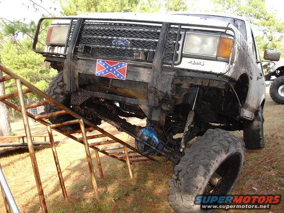 1989 Ford Bronco with custom bull bar and large tires on a metal ramp