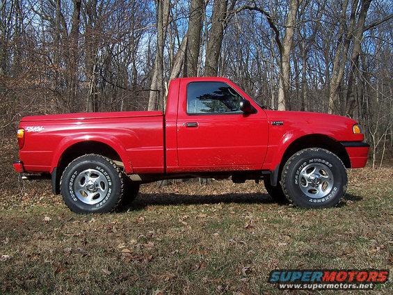 Red 2001 Mazda B3000 pickup truck parked in a wooded area