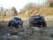 1994 Ford F-250 - Two modified trucks, a blue Toyota and a red Ford, tackle a rocky off-road course.