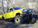 1994 Ford F-250 - This modified Jeep Comanche pickup truck is equipped with massive off-road tires for challenging terrain.