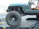 1994 Jeep YJ - This Jeep is on a trailer, with its front fender removed, revealing the suspension system and large off-road tires.