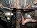 1994 Jeep YJ - Close-up view of the undercarriage, showing suspension components and exhaust system with visible fluid lines.